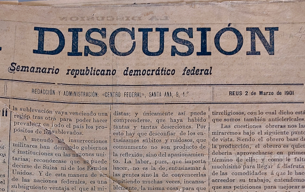 Eine gelblich vergilbte, leicht zerknitterte Zeitung mit der Aufschrift 'Diskussion' in schwarzer Tinte, die die Schlagzeile 'Semanario Repúblicano Democrático Federal' trägt.