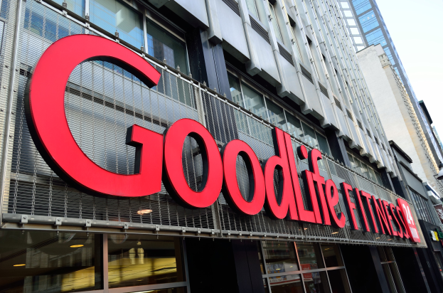 Außenansicht eines Goodlife Fitness Studios in New York City mit Glaswänden, einem Namensschild, benachbarten Gebäuden und dem Himmel im Hintergrund.