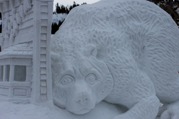 Schneekunst im Vordergrund mit ein paar Bäumen und einem Himmel-Hintergrund.