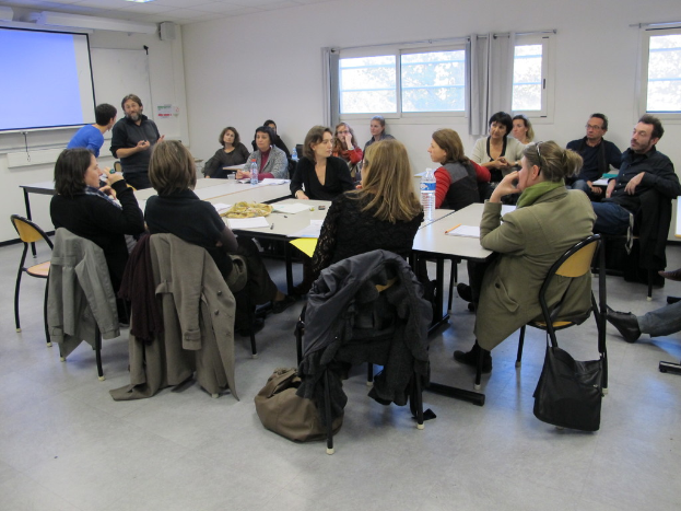 Eine Gruppe von Menschen, die sich unterhalten, mit zwei Personen im Hintergrund, die miteinander sprechen.