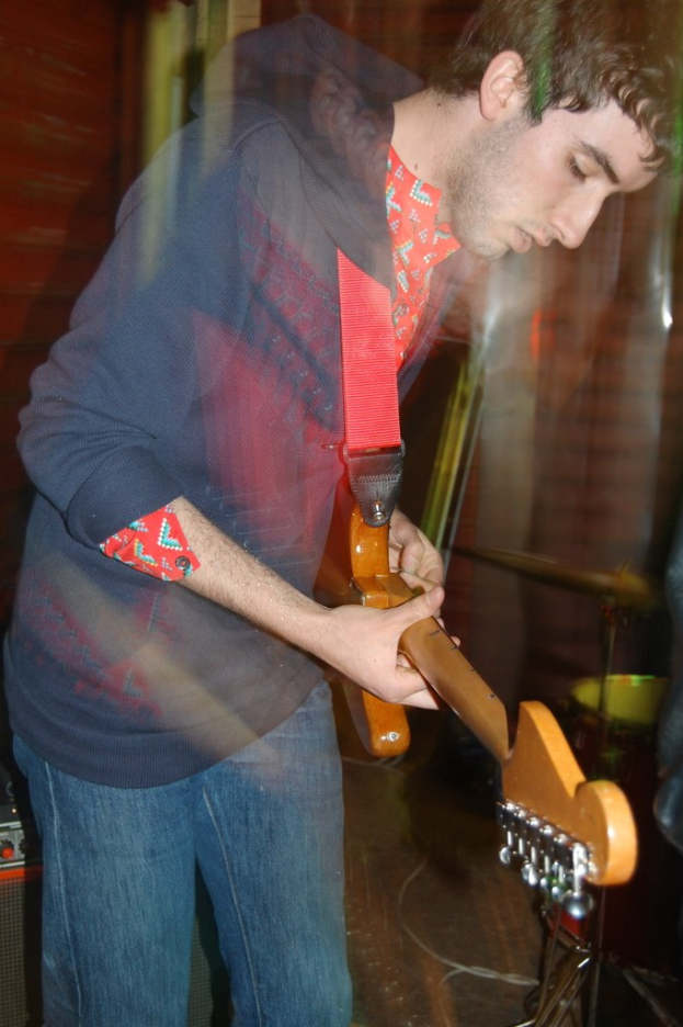 Ein Mann, der eine Akustikgitarre spielt.