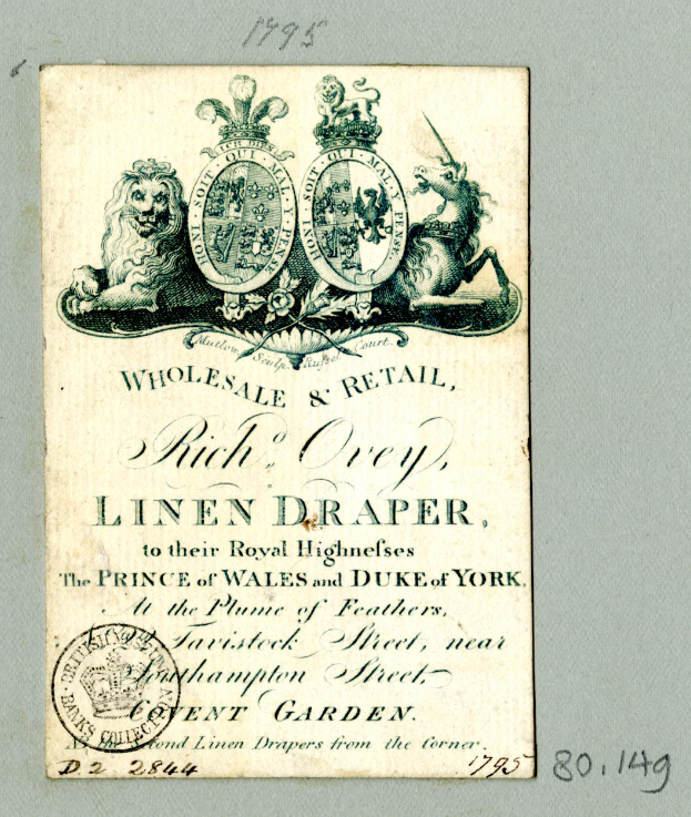 Eine alte Visitenkarte mit einem majestätischen Löwen, der seinen Kopf hochhält und eine Mähne trägt, sowie dem Text "Groß- und Einzelhandel, Rich Orey, Leinenhändler" und einem Stempel.