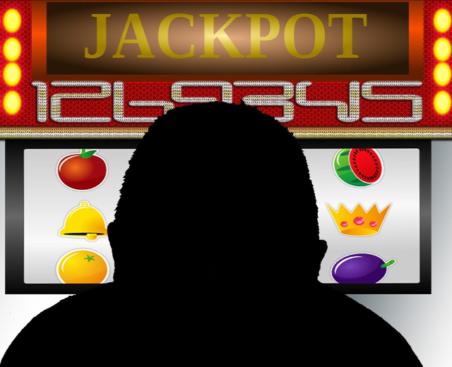 Ein Mann spielt einen Online-Slot-Automaten mit einer "Jackpot"-Anzeige, umgeben von einer Tafel mit Text- und Obstbildern.