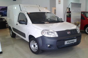 Ein weißer Fiat Fiorino 1.3 Multijet 95 CV Pop Star in einer Ausstellungshalle umgeben von schwarzen Schlafzimmermöbelsets.