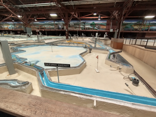 Großes Indoor-Wasserpark mit mehreren Wasserrutschen, Deckenbeleuchtung, Wandgemälden und einem Minigolfplatz.