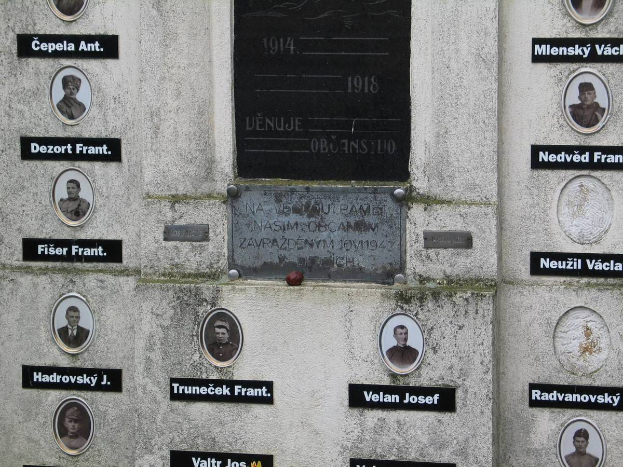 Eine Gedenktafel an einer Wand, die Fotos von Personen und Text enthält, erinnert an die Opfer des Zweiten Weltkriegs.