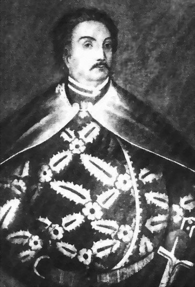 Schwarzes und weißes Foto von Papst Johannes Paul II. in Priestergewändern, der eine schwarze Robe mit weißem Kragen und Manschetten trägt, die Hände gefaltet, ernster Gesichtsausdruck, direkt in die Kamera schaut.