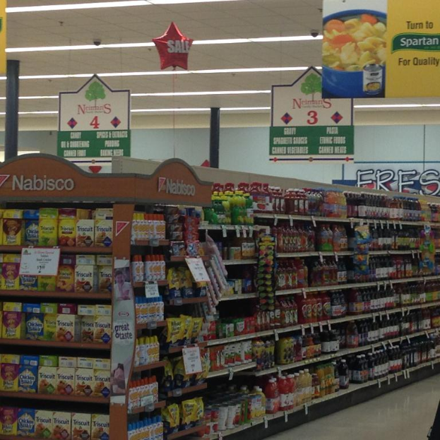 Ein Supermarkt-Innere mit Lebensmitteln, Deckenleuchten und Schildern.