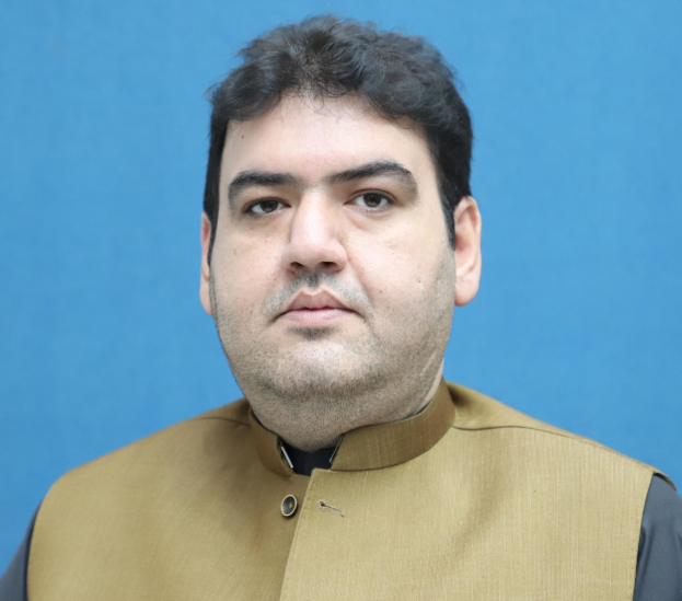 Ein Mann in brauner Weste und schwarzem Hemd steht vor einem blauen Hintergrund und sieht verzweifelt und hoffnungslos aus, wahrscheinlich wegen einer lebenslangen Haftstrafe.