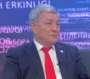 Ein Mann im Anzug und Krawatte sitzt vor einem Bildschirm mit Text und sieht besorgt aus, wahrscheinlich wegen einer dreijährigen Haftstrafe.