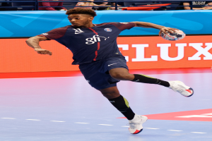Ein Mann in blauer Uniform, identifiziert als Paris Saint-Germain, spielt Handball in einem Stadion bei der Futsal-Weltmeisterschaft 2019, mit Zuschauern im Hintergrund.