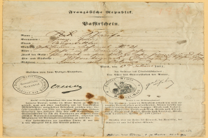 Ein altes, gelbliches Dokument mit einem kreisrunden, schwarz umrandeten Stempel, wahrscheinlich ein Brief der deutschen Regierung, geschrieben in schwarzer Tinte.