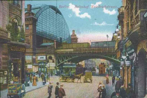 Alte Ansichtskarte einer belebten Straßen in Berlin, Deutschland, mit Passanten, Pferdewagen, Gebäuden, Laternen, einer Brücke und einem bewölkten Himmel mit Text oben.