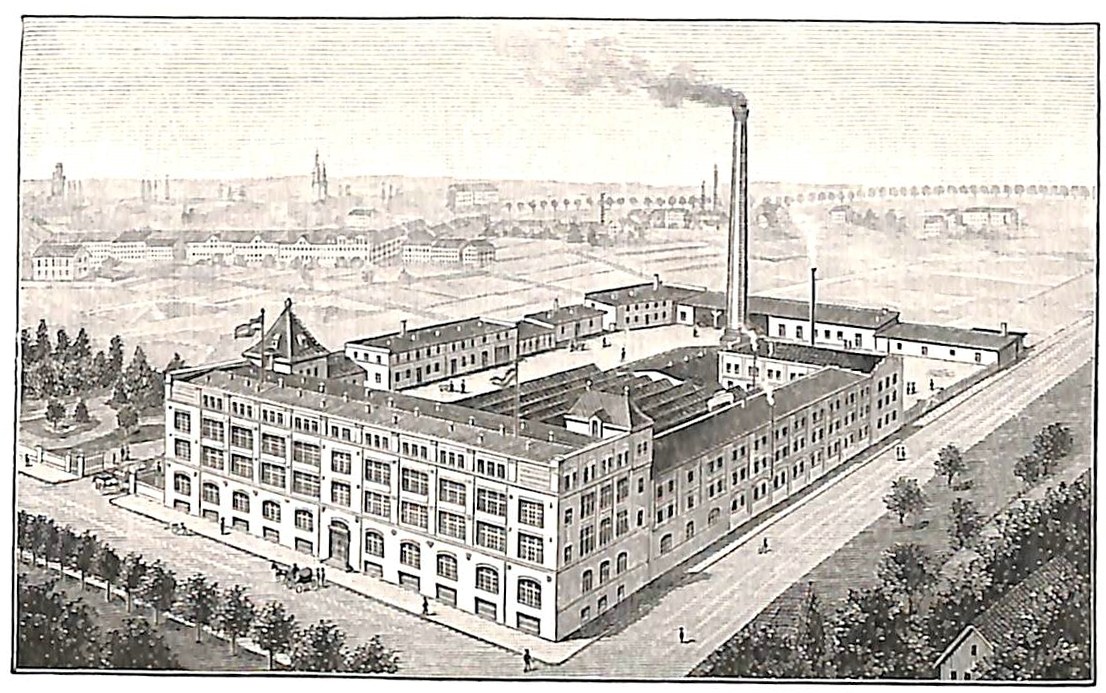 Alte Fabrik mit großem zentralen Gebäude umgeben von Bäumen, Text unten.