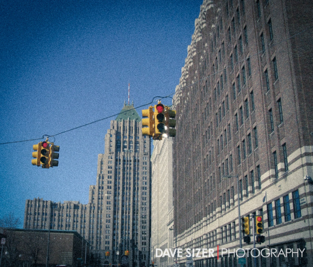 Mehrere Ampeln auf Masten vor Gebäuden.