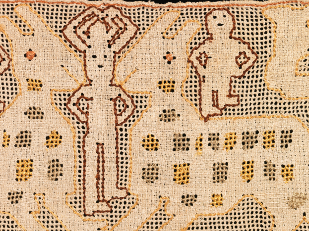 Nahaufnahme eines gemusterten Textils mit verschiedenen Formen und Farben in einem komplexen Design.