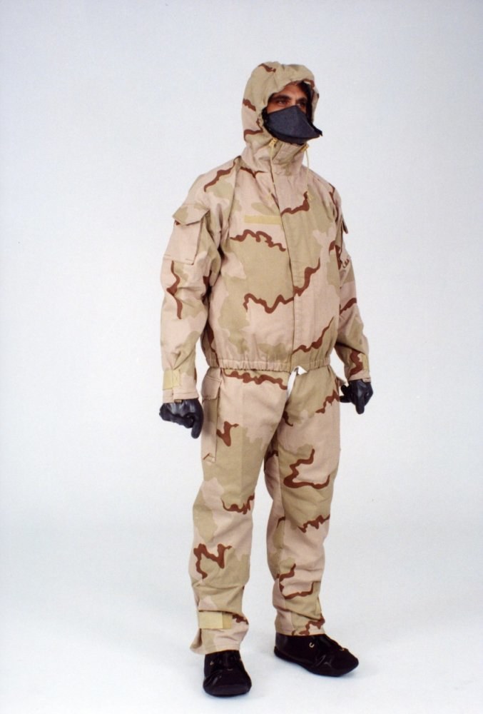 Mann in einem Tarnmuster-Schutzoverall und Maske vor einem weißen Hintergrund.