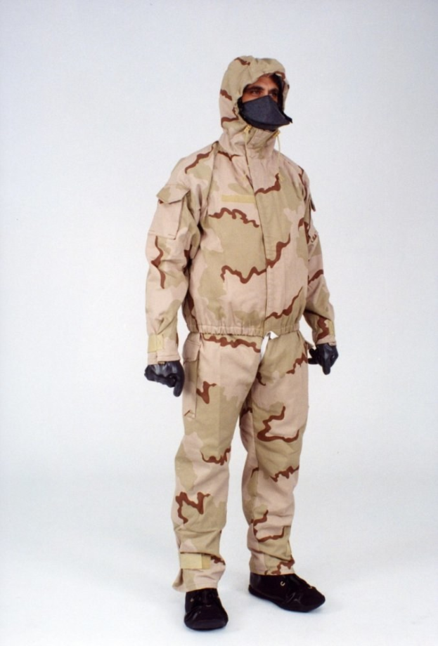 Mann in einem Tarnmuster-Schutzoverall und Maske vor einem weißen Hintergrund.