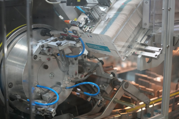Automatisiertes Verpackungssystem auf einem Fabriktor mit unscharfen Hintergrundobjekten.